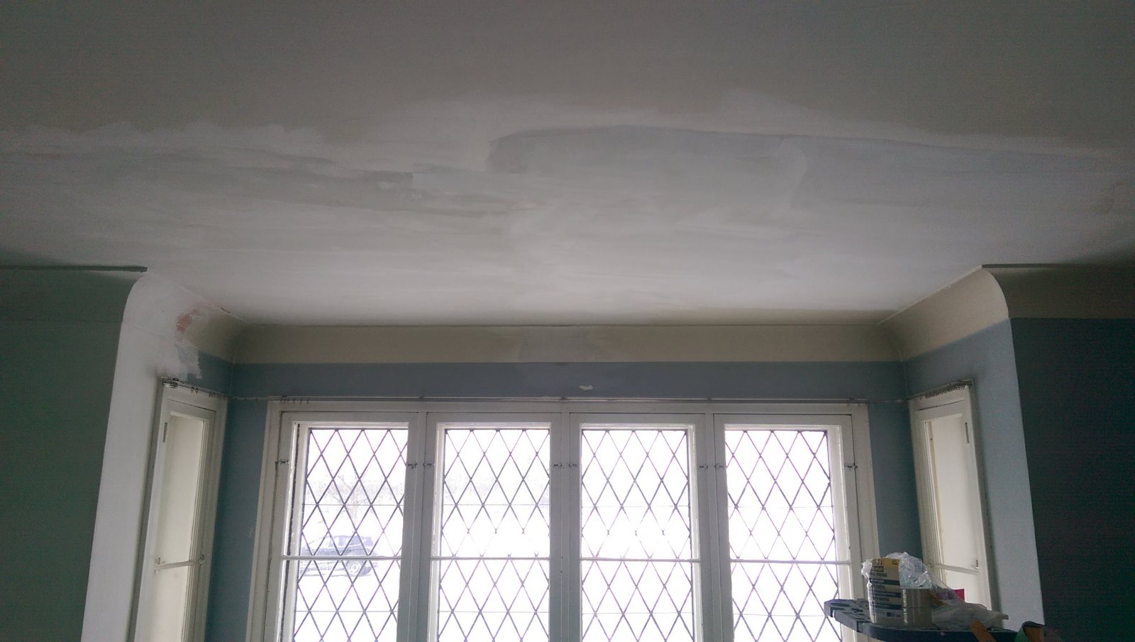 A bay of diamond-leaded casement windows in an Ottawa Tudor house, walls being finished around them